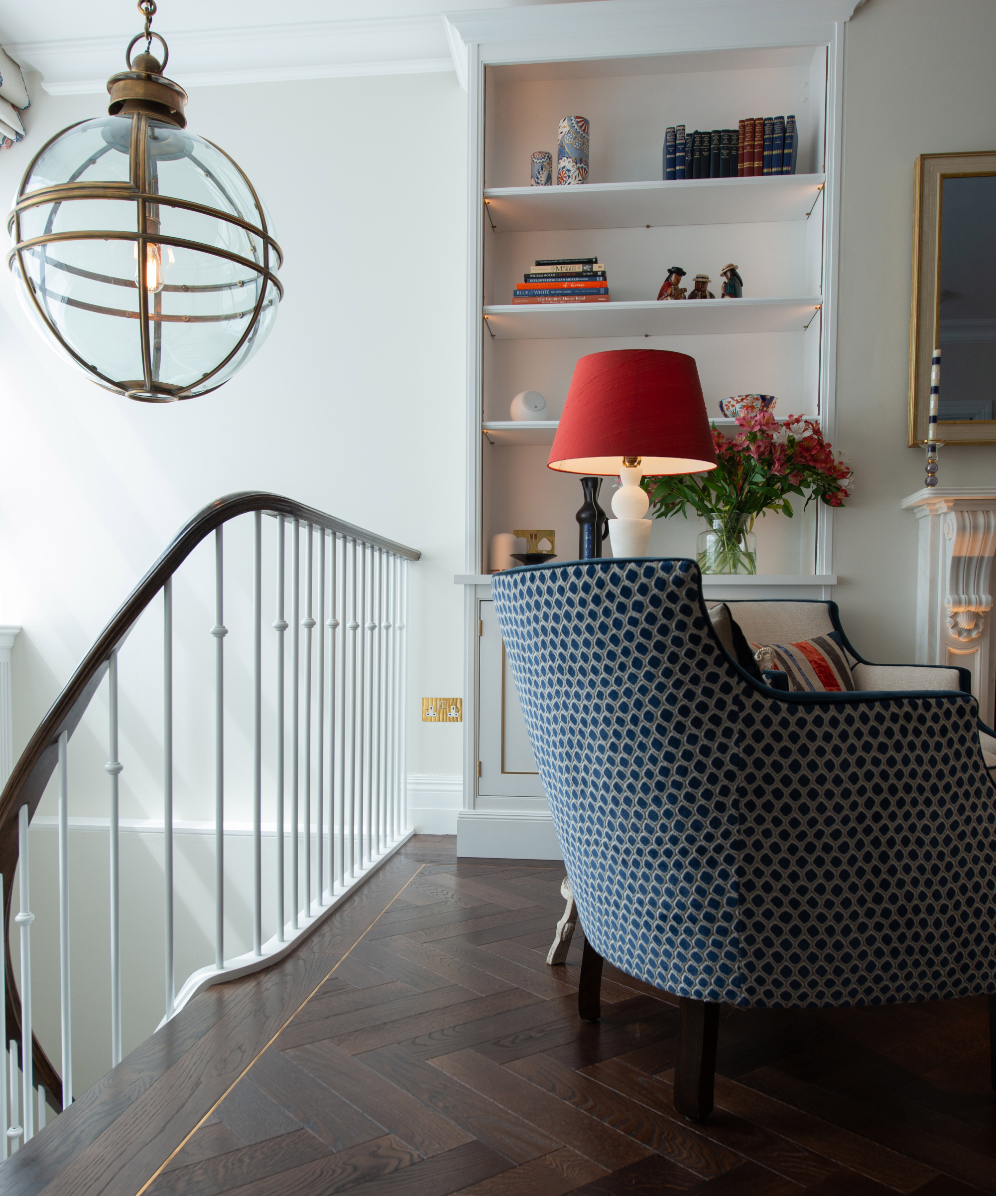 dark wooden flooring on landing with blue chair and built in storage shelf