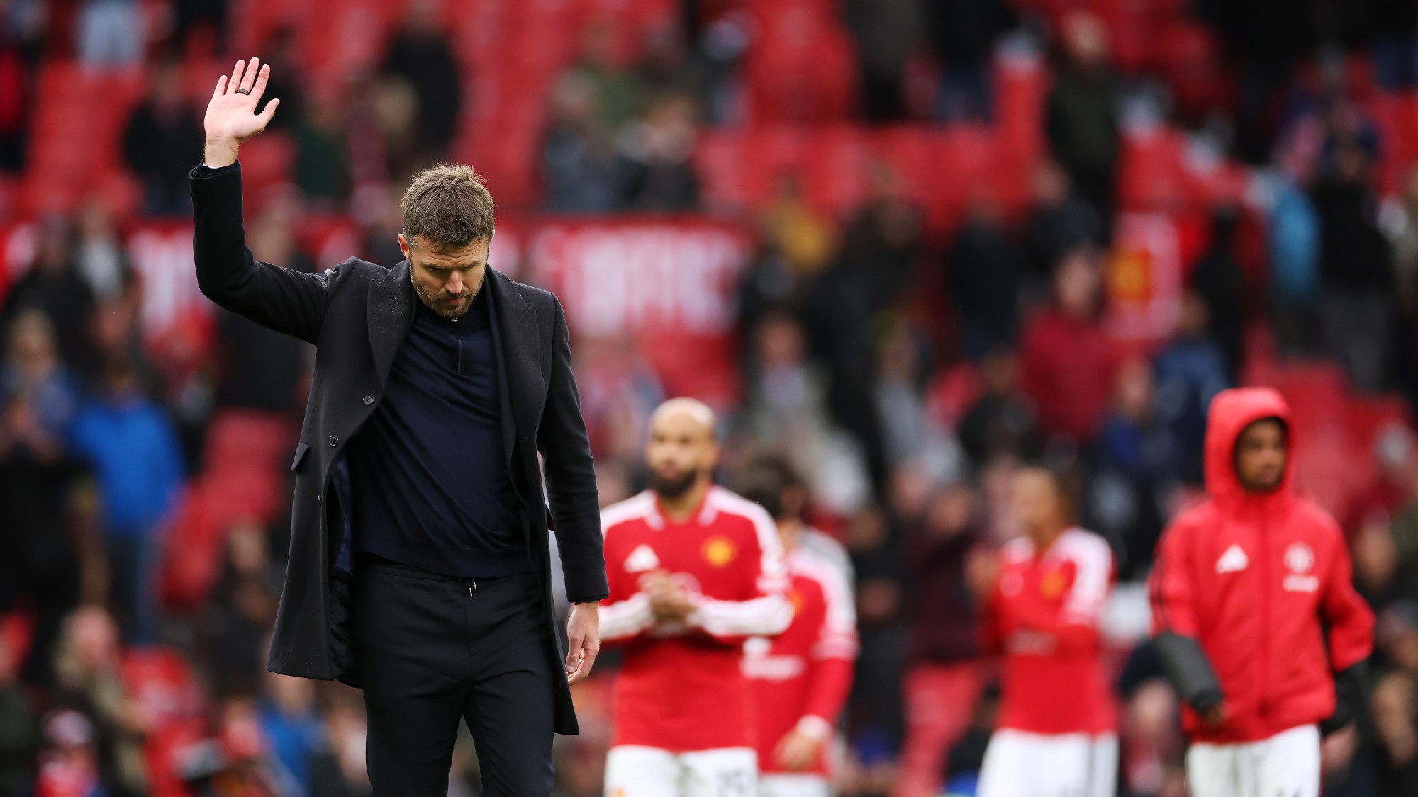 Michael Carrick, looking down, waves to fans at the end of a match between Manchester United and AFC Bournemouth at Old Trafford