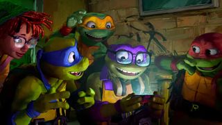 (L to R) April, Leonardo, Michelangelo, Donatello and Raphael in Teenage Mutant Ninja Turtles: Mutant Mayhem, huddled around a phone