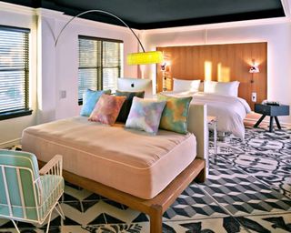 An example of a Mama Shelter hotel room with bed, mattress, patterned monochrome carpet