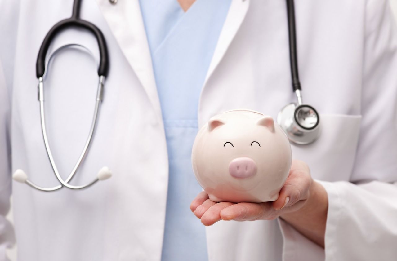 Doctor holding piggy bank