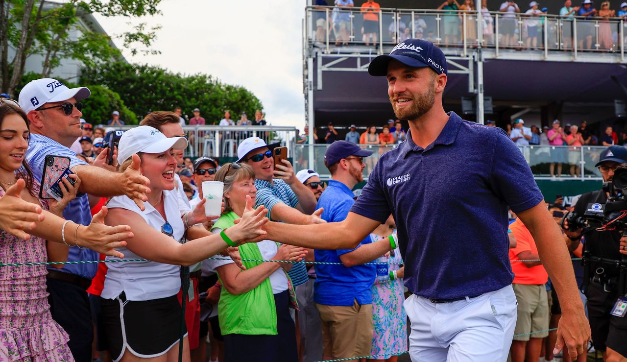 Wyndham Clark high fives fans as he walks off the 18th green