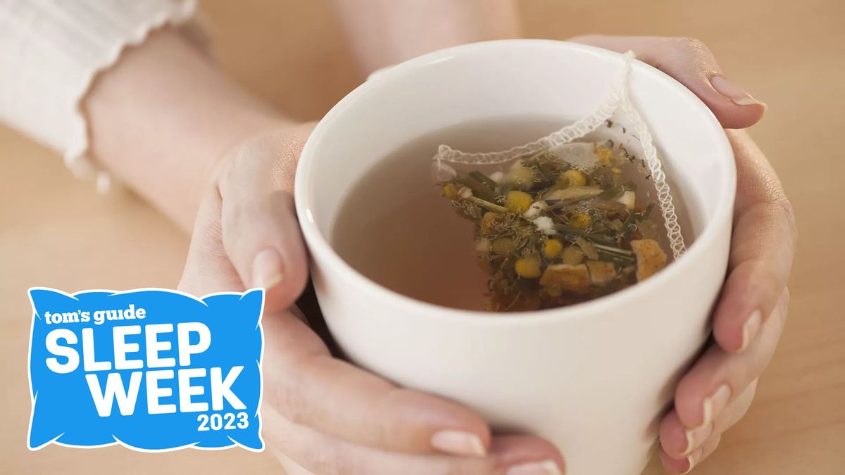 Woman&#039;s hands holding a mug of chamomile tea