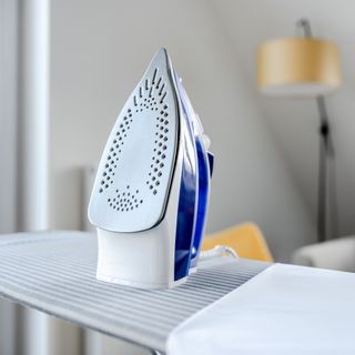 Steam iron propped up on top of ironing board