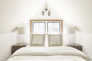 bedroom with sloping roof side tables and white bedding