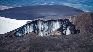 A sinkhole in the permafrost shows thawing due to climate change.