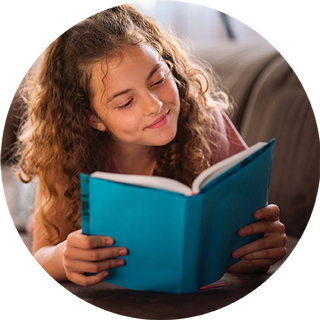 Image of young girl reading a book with a blue cover