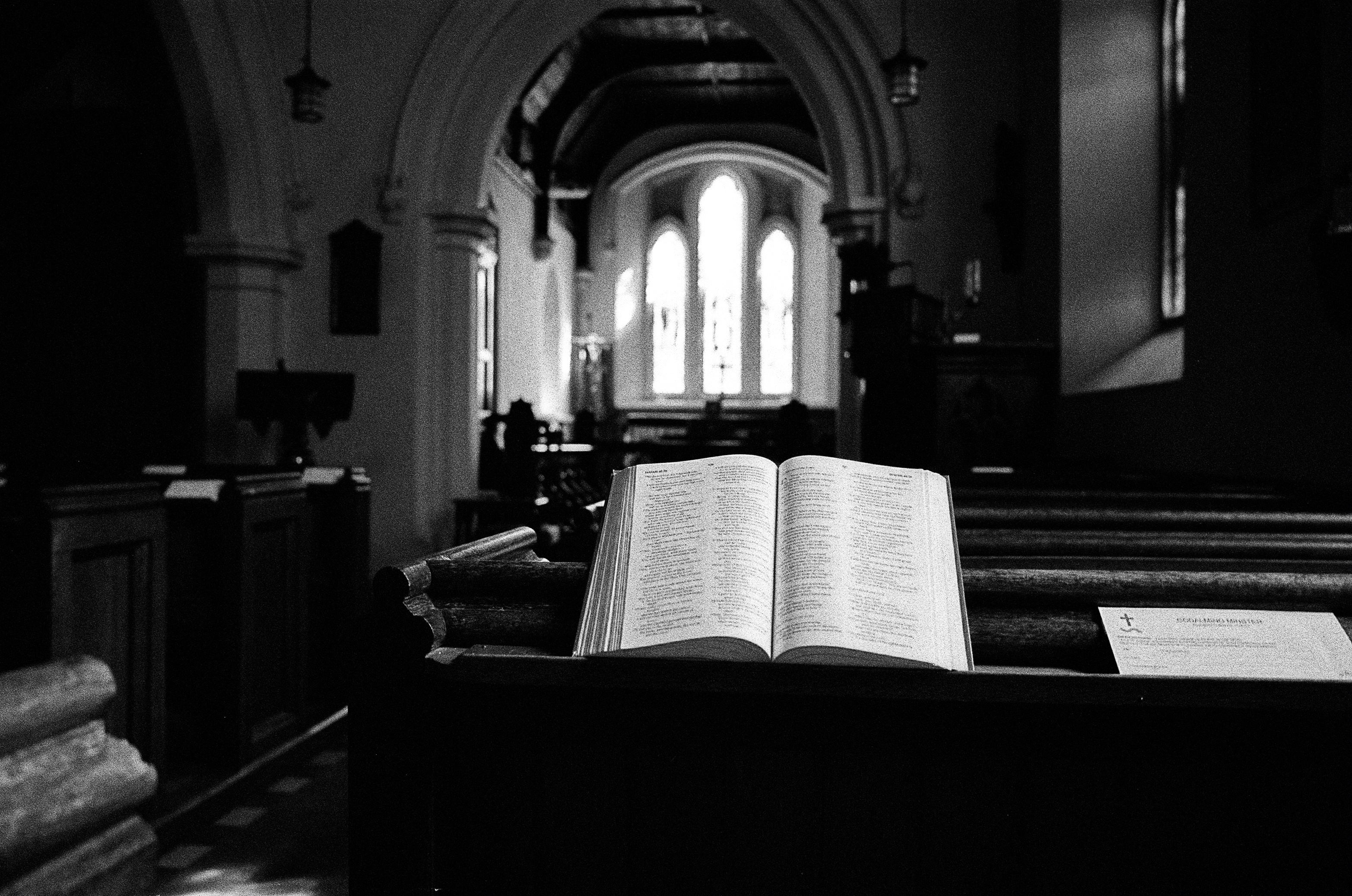 Leica MP black and white film scan of a bible on a pew in an old church