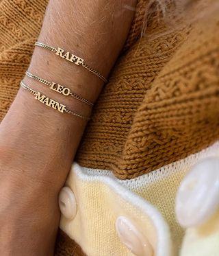 gold name bracelets worn on the wrist