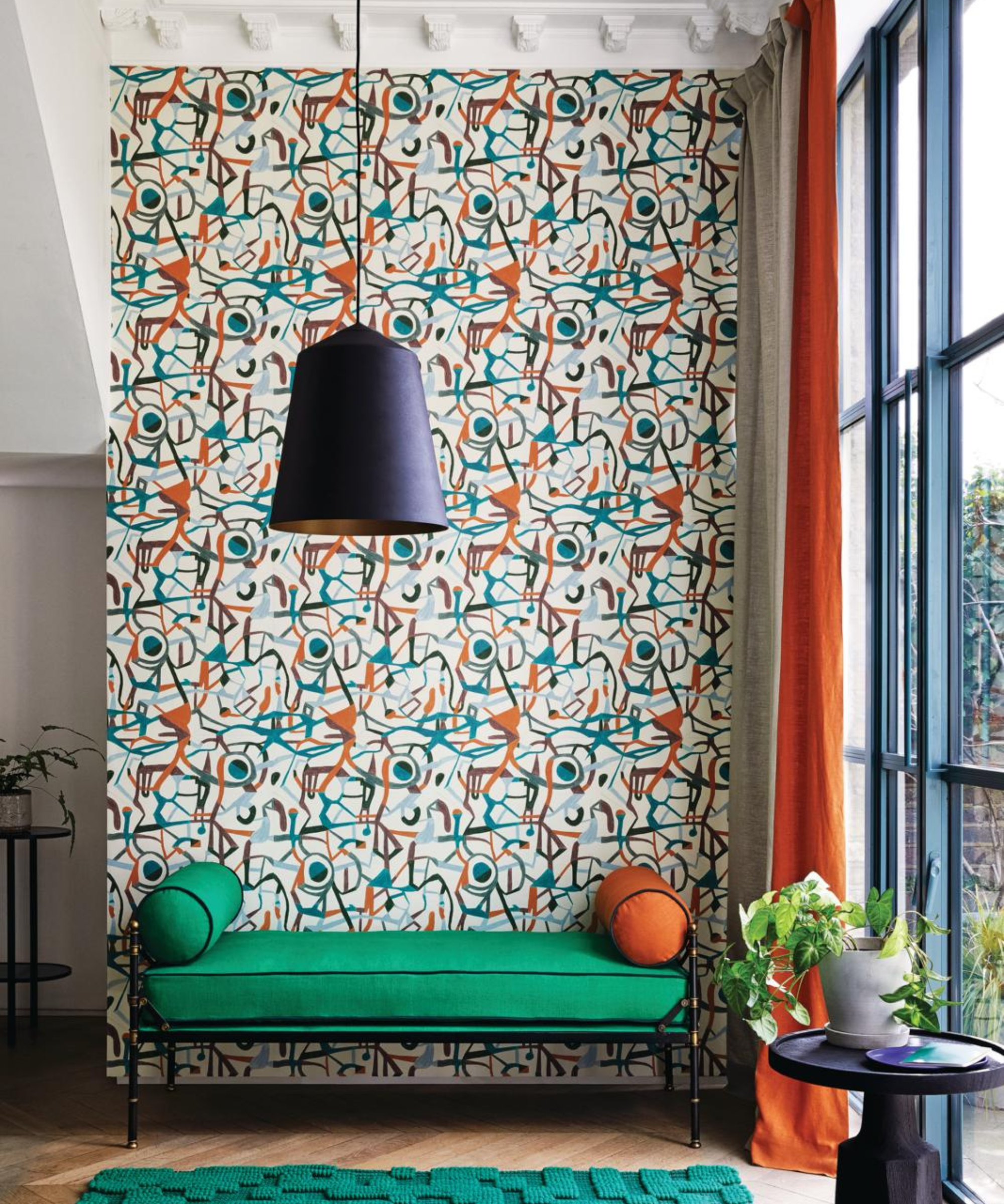 a green bench against a wall with an abstract and retro wallpaper