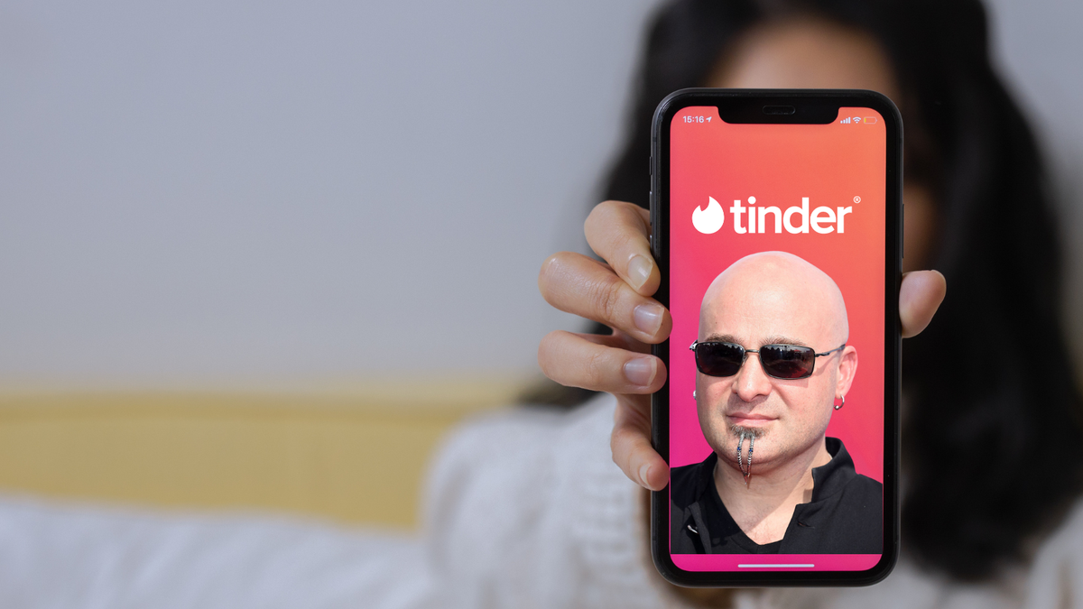 A heavily edited picture to show David Draiman&#039;s face on a phone screen with the Tinder logo