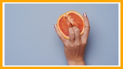 Cropped studio shot of an unrecognizable woman putting her fingers into a grapefruit against gray background, how to masturbate suggestive