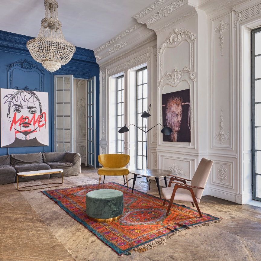 interior of a mansion with chic furniture, big windows, and wood floors