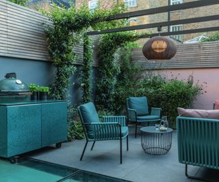 small patio with outdoor kitchen area, seating and wooden pergola