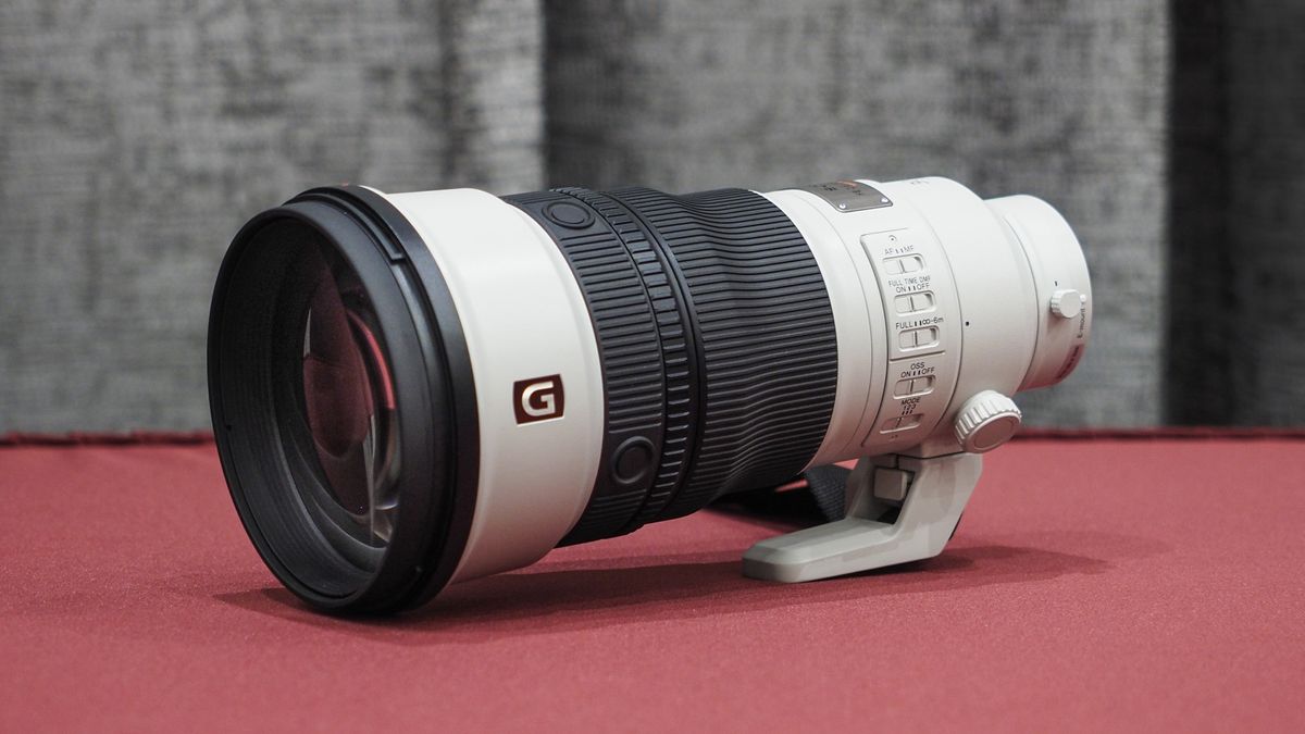 Sony FE 300mm f/2.8 GM OSS lens on a red table with grey curtains