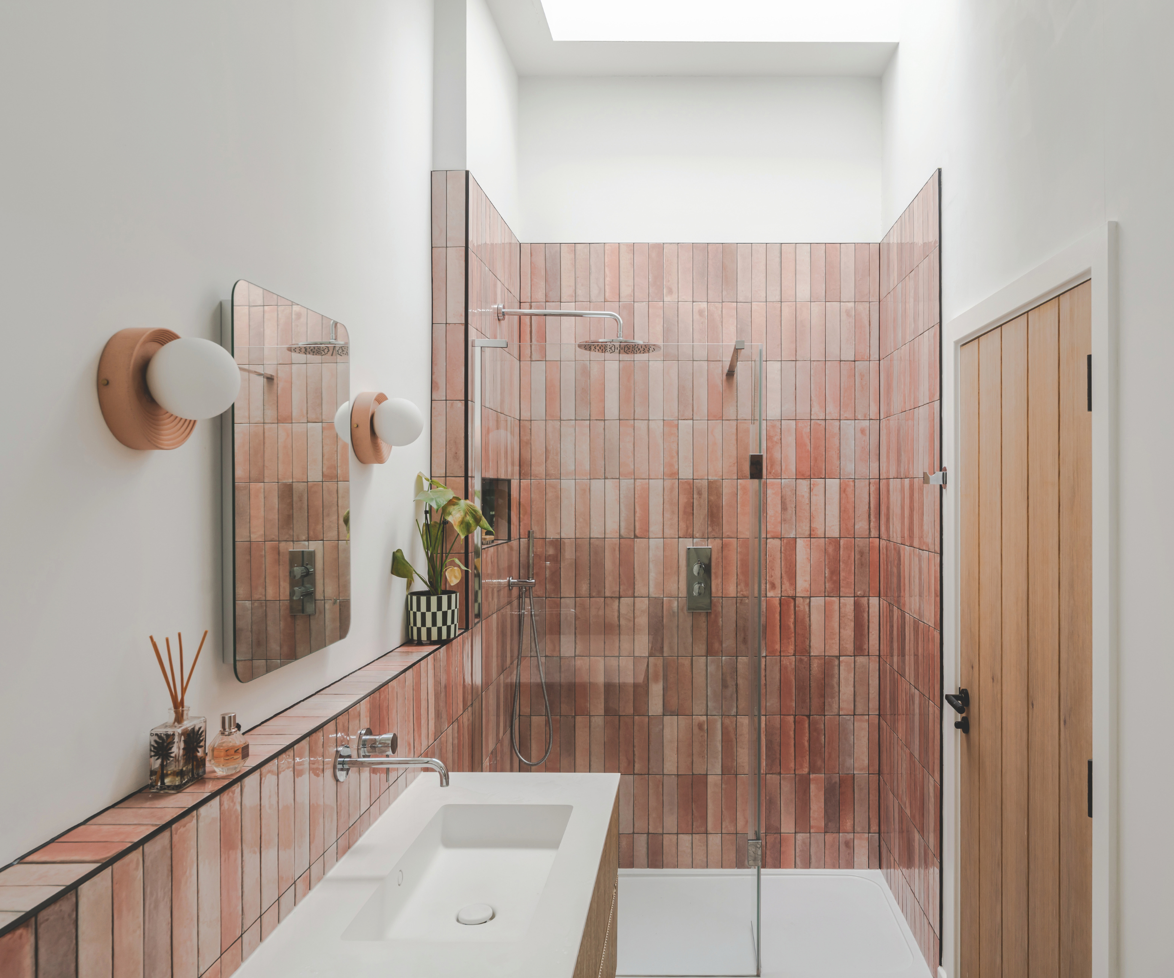 Bathroom with pink rectangle tiles and roof light above the shower enclosure