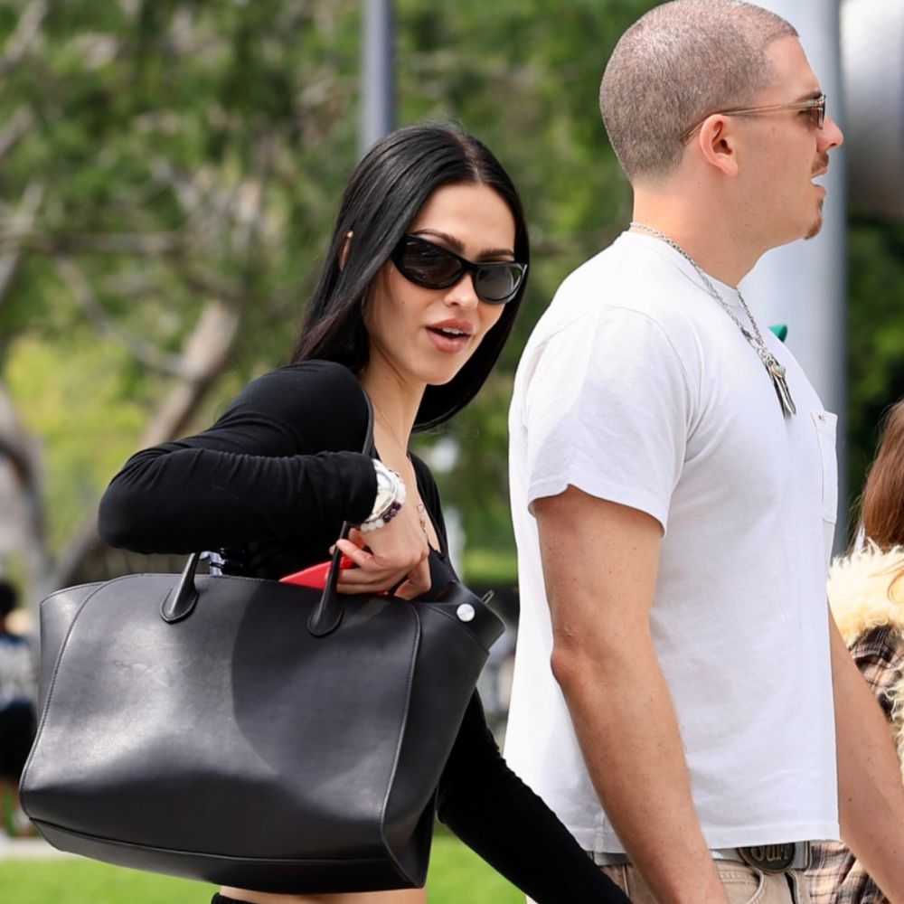 Amelia Grey Hamlin walks down the street wearing capri joggers with black ballet flats, a black long sleeve top and sunglasses.
