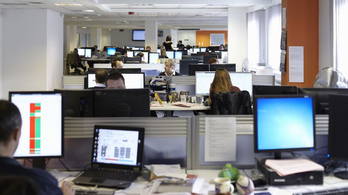 An open plan office with many people working at computers