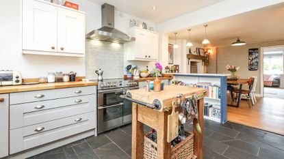 neutral Shaker kitchen with wooden butchers block and slate flooring