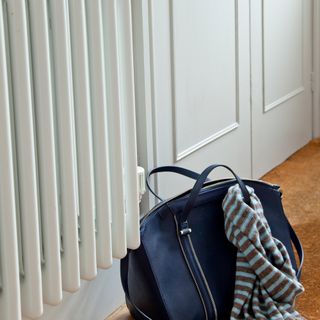 white radiator in hallway with bag