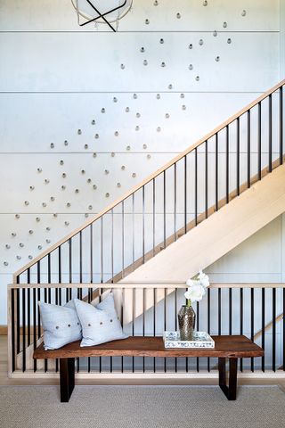 A side view of a staircase with art objects across the entire wall