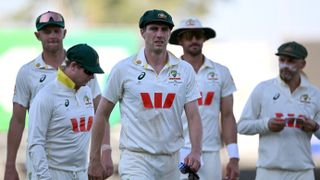 Australia's captain Pat Cummins (C) leads his players off at the end of the second day of the first cricket Test match between Australia and Bangladesh