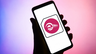 The eRoaming eSIM logo on a phone screen held by a silhouetted hand