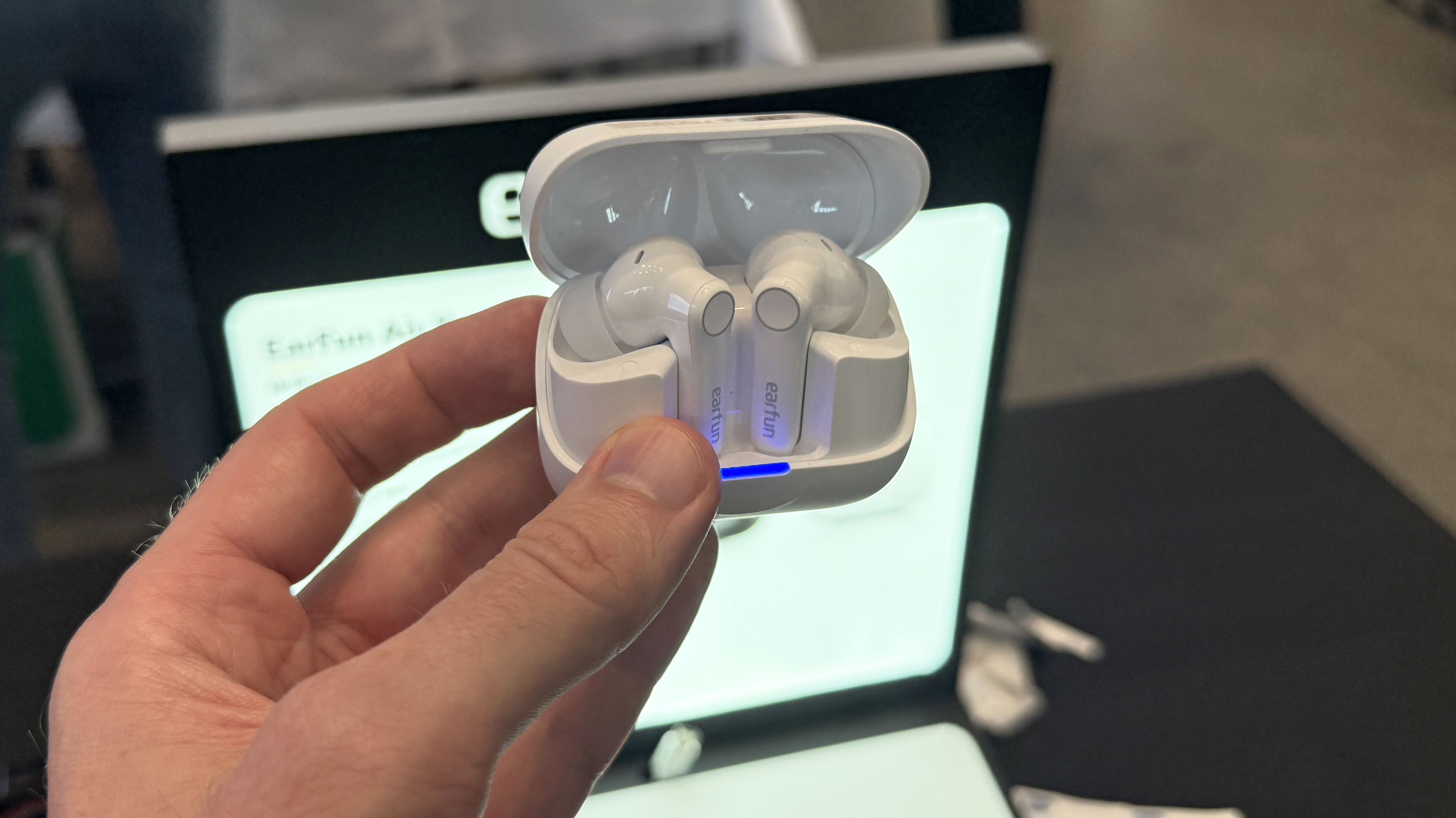 Earfun Air Pro 4+ in their case, held in a man&#039;s hand