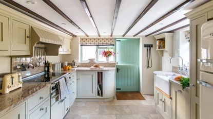 Kitchen with cream wall and white counter with green door