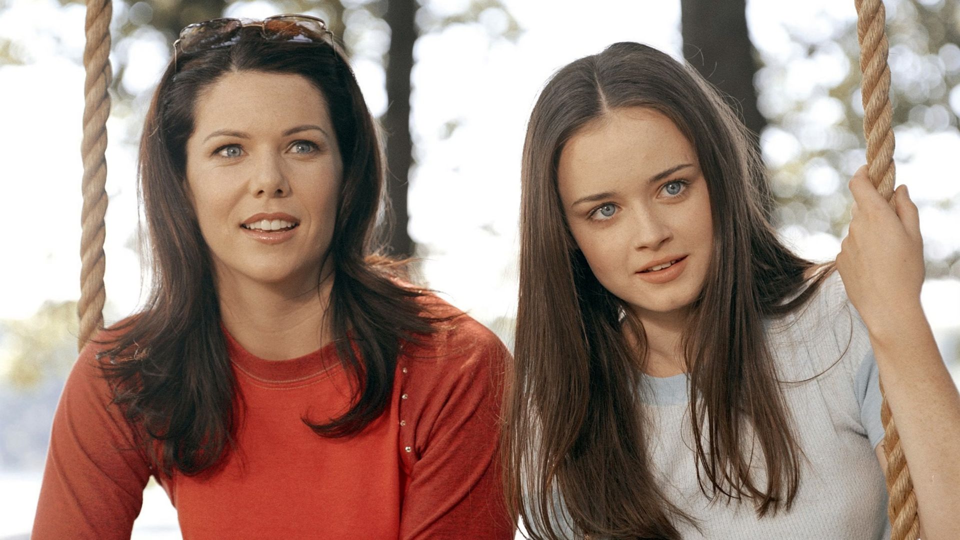 Lorelai and Rory sit on a swing looking dumbfounded