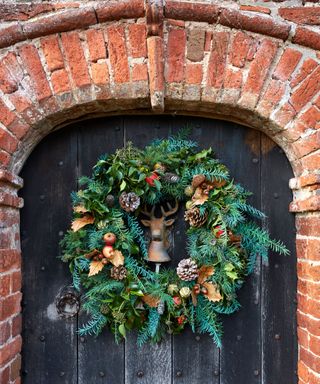 christmas wreath made from natural foliage hung on an old wooden door