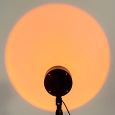 close up of illuminated sunset lamp on table against wall