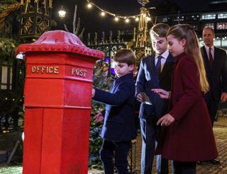 Prince Louis, Prince George and Princess Charlotte during the Royal Carols posting letters - Together At Christmas service at Westminster Abbey on December 8, 2023