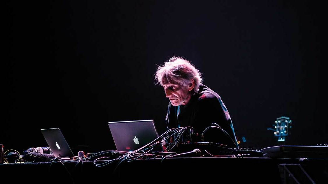 Manuel Gottsching hunches over a laptop at the Barbican,