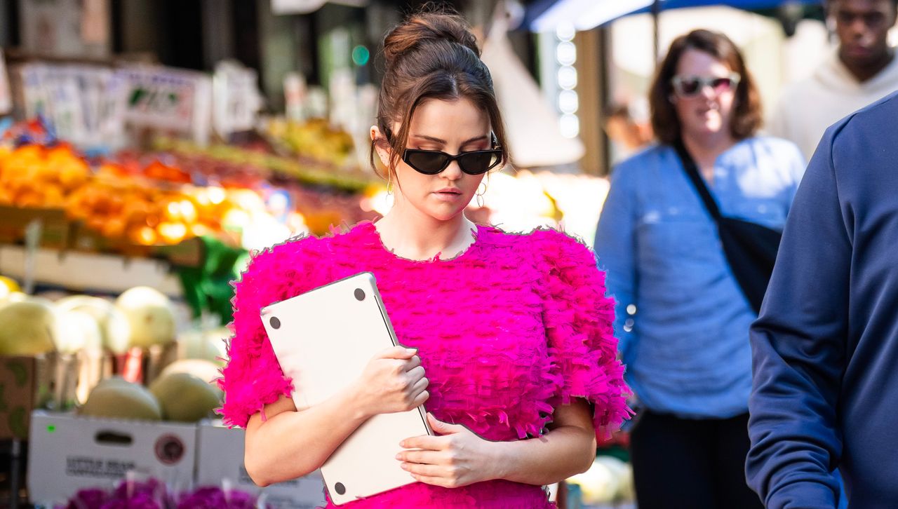 Selena Gomez in New York City wearing a bright pink dress with puff sleeves and sunglasses