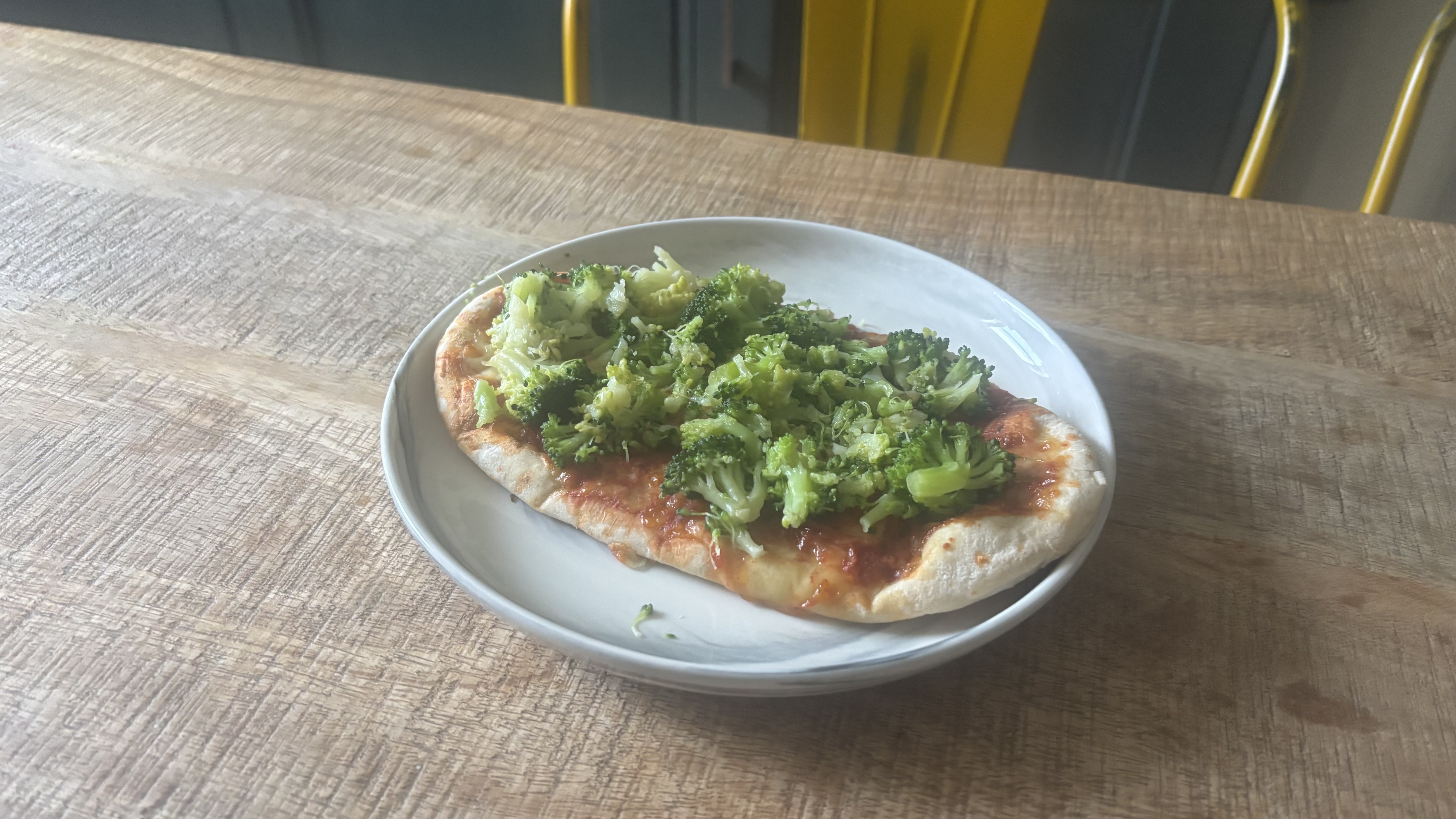 Broccoli on a slice of pizza.