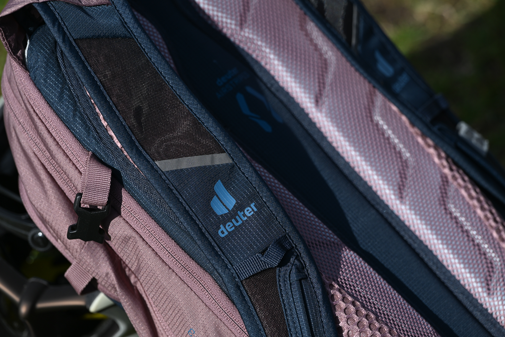 close up of a the shoulder strap on a pink and blue Deuter backpack