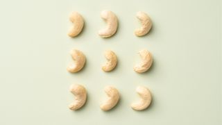 Cashew nuts on green background