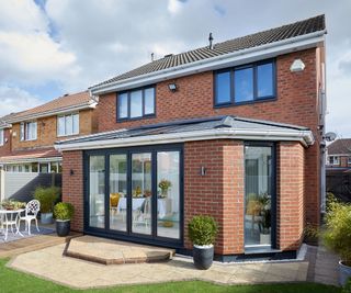 brick-clad prefab extension with bifold doors and slate roof