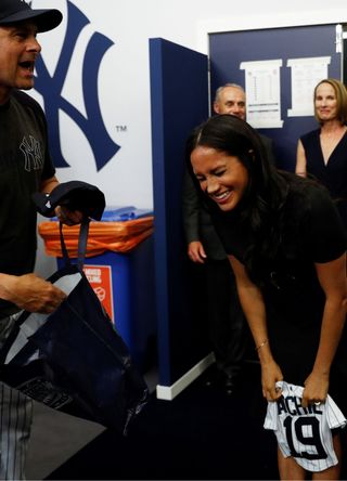 Manager Aaron Boone of the New York Yankees presents a gift for Archie to Prince Harry, Duke of Sussex and Meghan, Duchess of Sussex