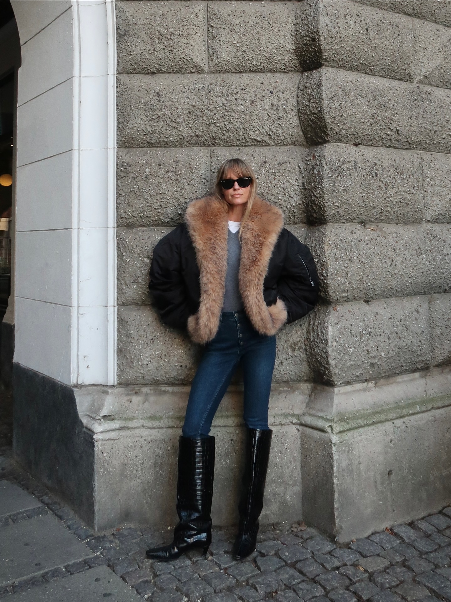Jeanette Madsen wears a bomber jacket, skinny jeans, and knee high boots