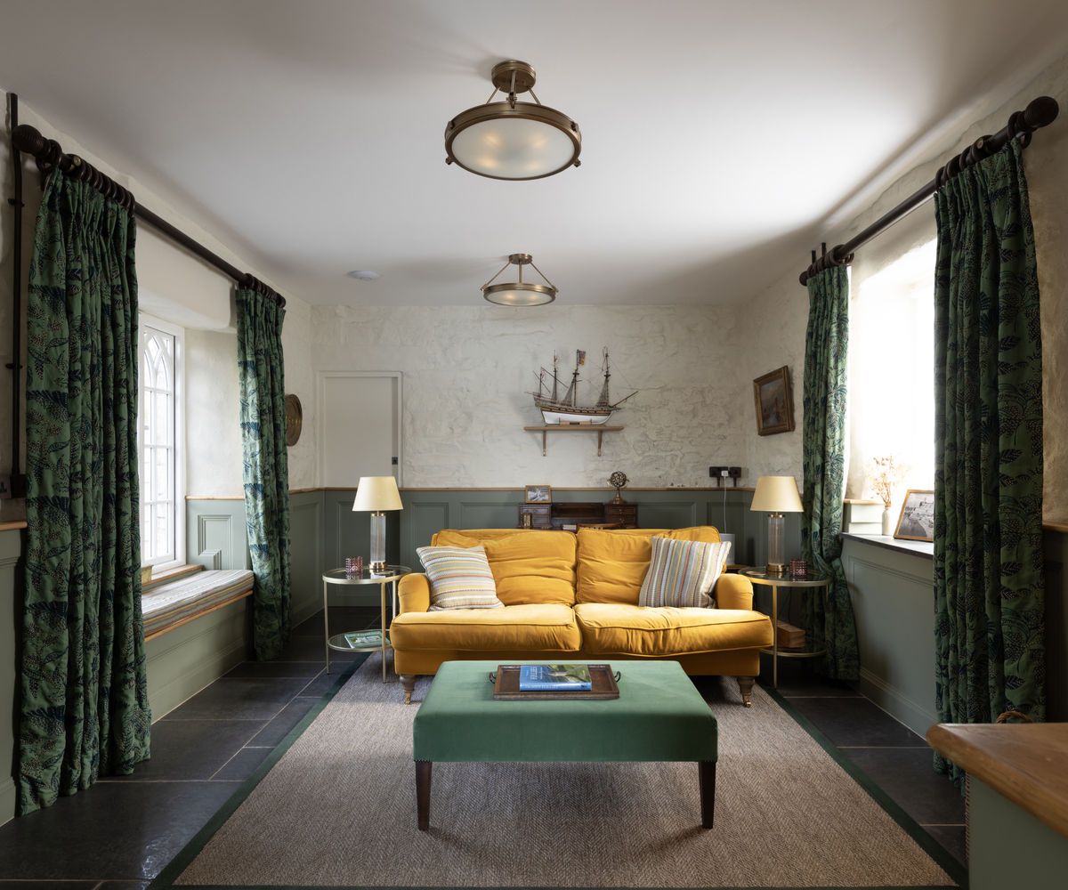 living room with yellow sofa, green table and curtains, and nautical style lights