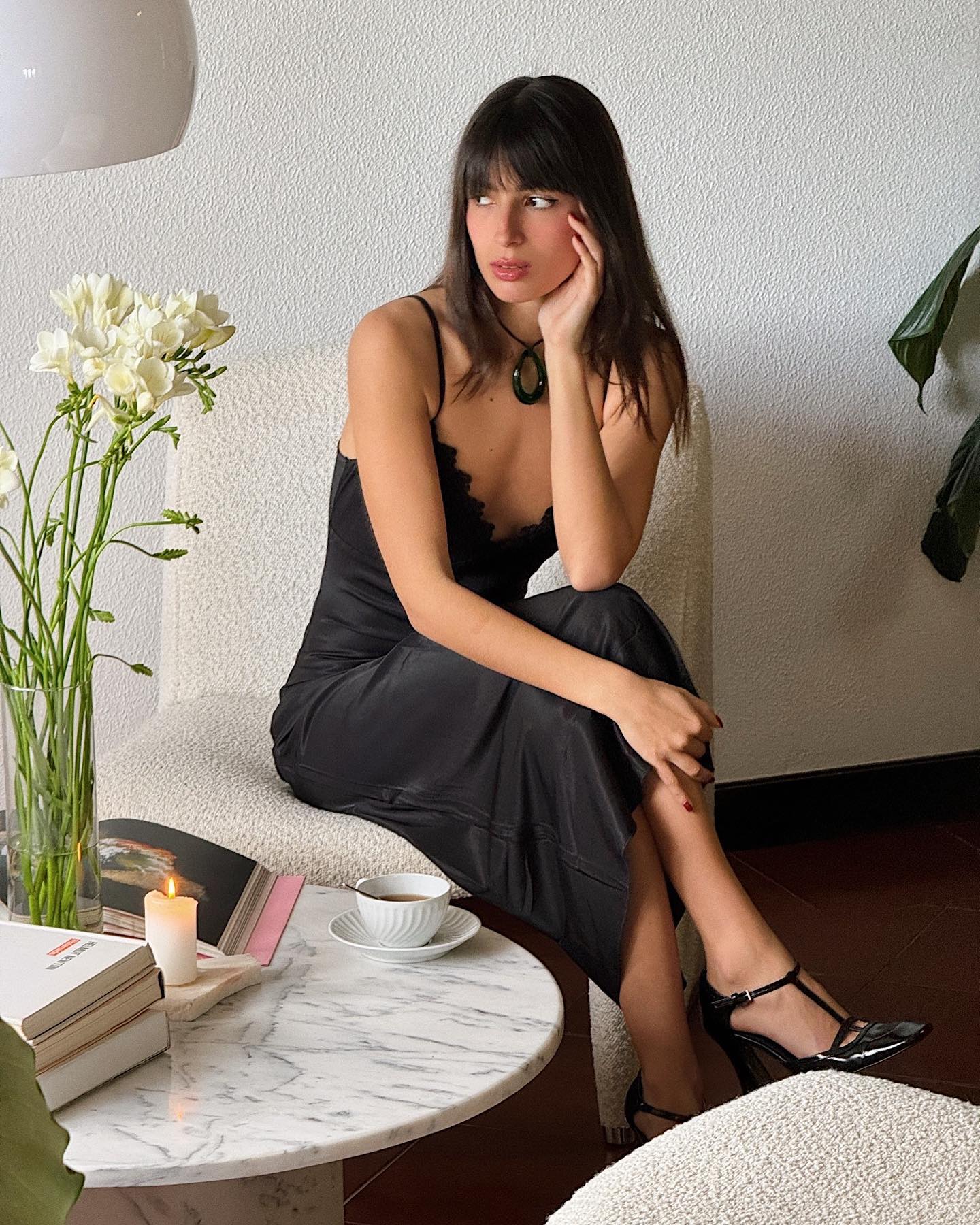 French woman wearing a black slip dress with patent leather shoes.