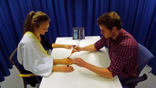 Study researcher Arvid Guterstam creating the third arm illusion on a participant.