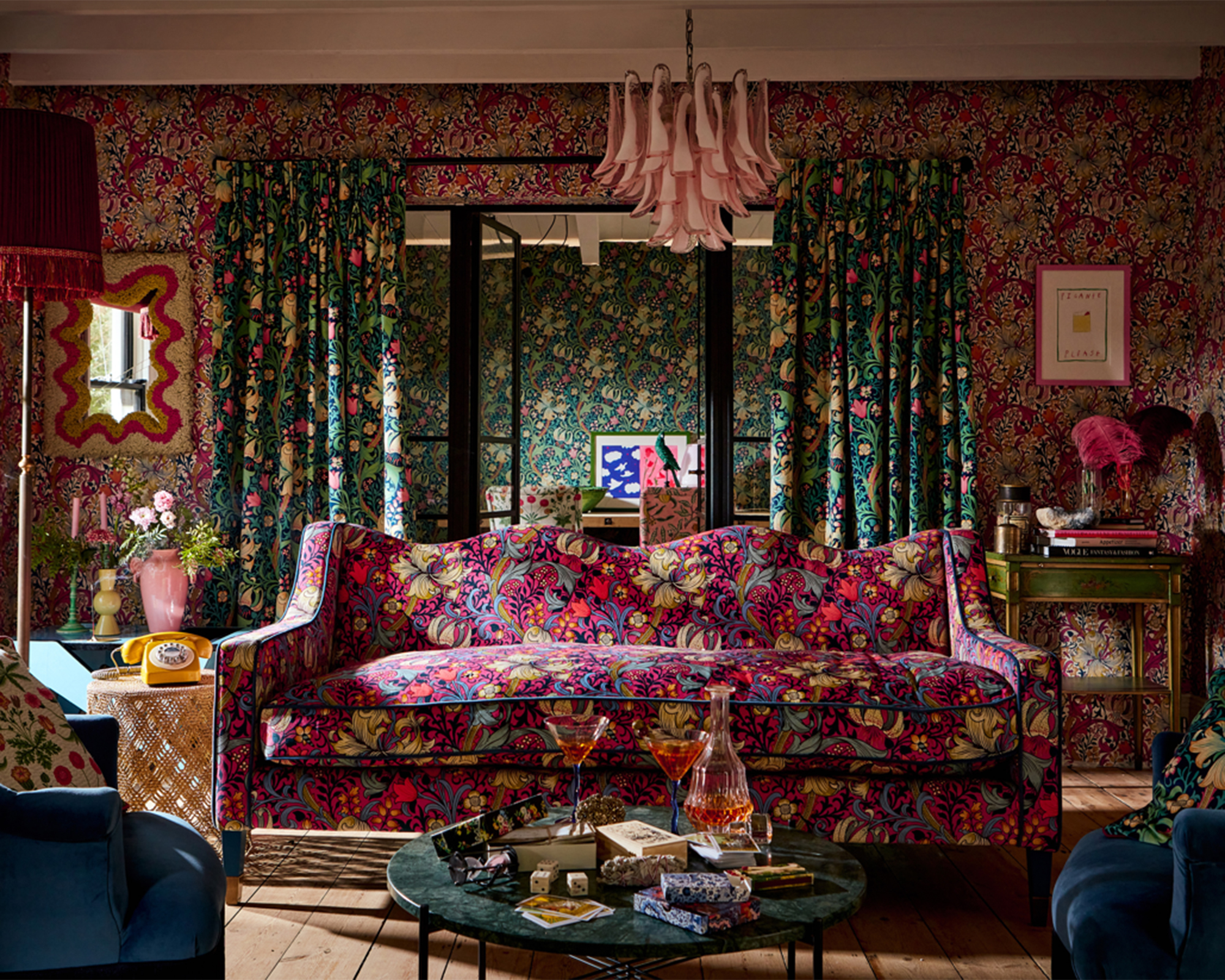 A modern maximalist living room idea with floral furnishings including furniture and wallpaper wall covering decor