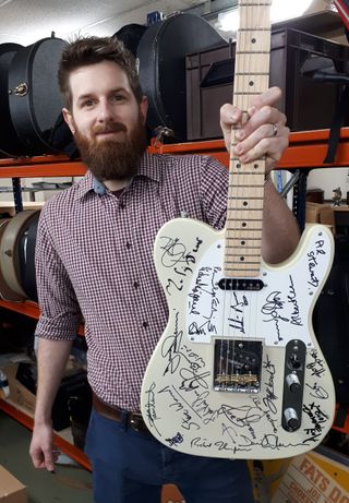 Luke Hobbs, auctioneer at Gardiner Houlgate, with the signed guitar