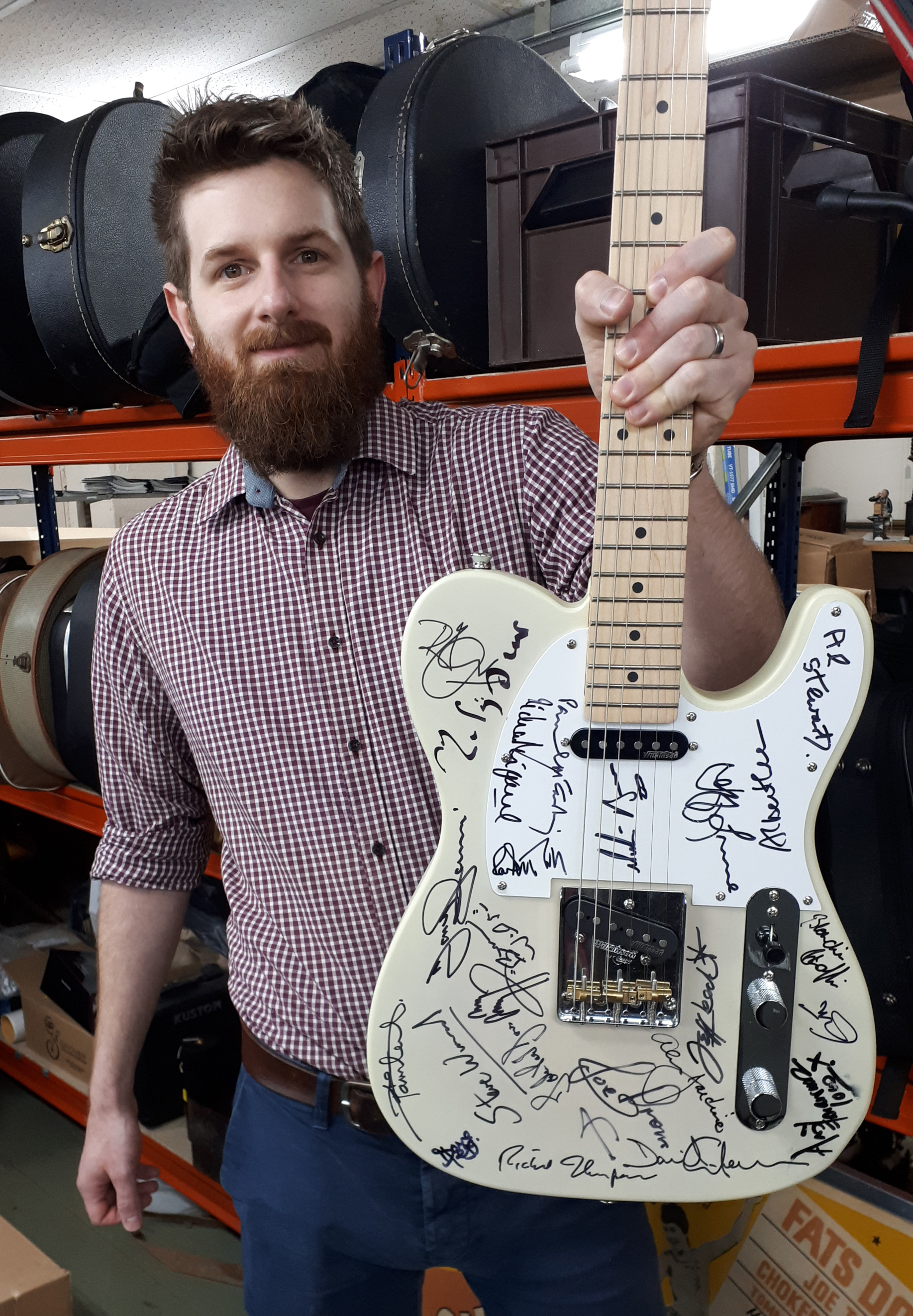 Luke Hobbs, auctioneer at Gardiner Houlgate, with the signed guitar