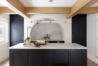 A kitchen with white walls and navy blue cabinets