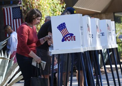 People vote at outdoor booths during early voting for the mid-term elections in Pasadena, California on November 3, 2018. 