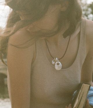 woman wears necklace on beach